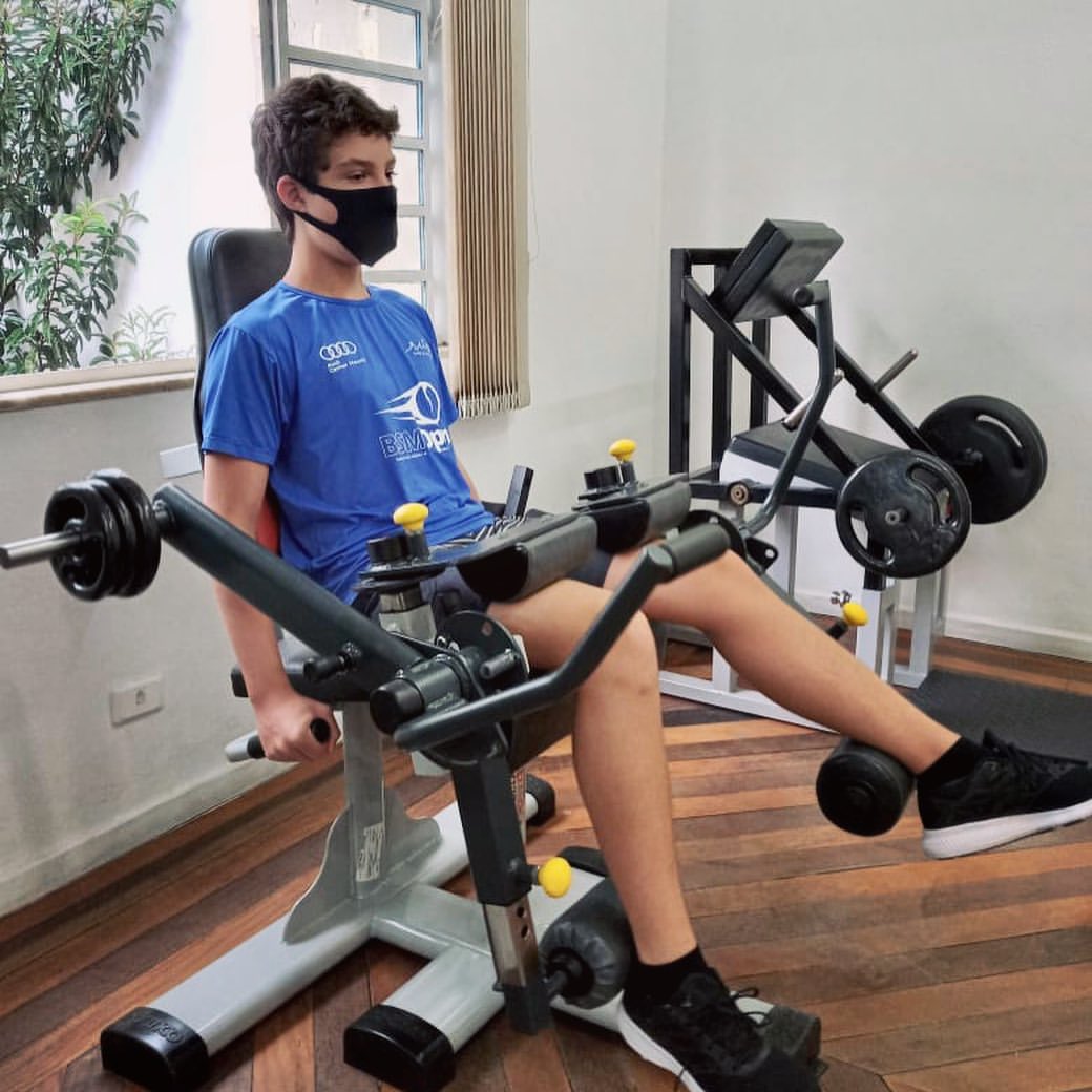 Aluno treinando as pernas na cadeira extensora