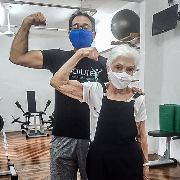 Professor e aluna da Salute mostrando o muque